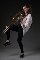 Fototapeta premium Portrait of a dancing girl with a trombone