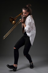 Portrait of a dancing girl with a trombone