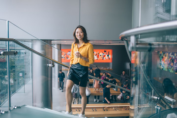 Happy young Asian woman walking on stairs