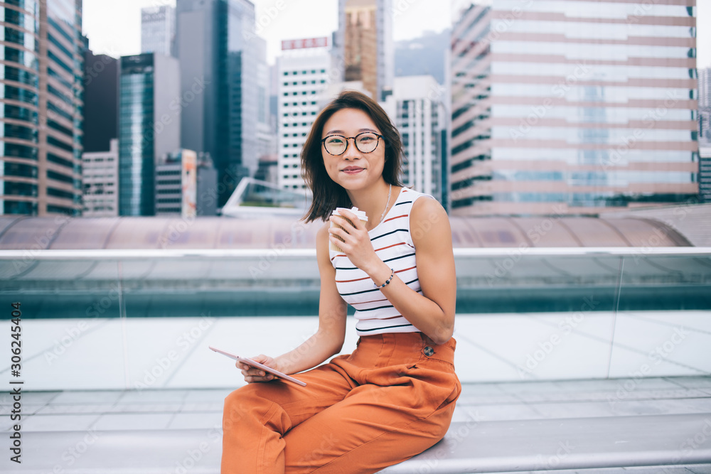 Poster portrait of chinese female blogger with digital tablet for networking in hand looking at camera and 