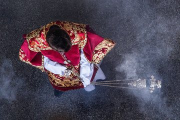 Acolyte of the Catholic Church balancing an incentive. Purifying souls.