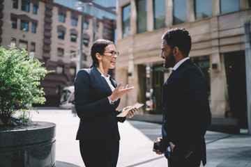Excited cheerful caucasian woman in elegant suit enjoying live conversation with turkish business...