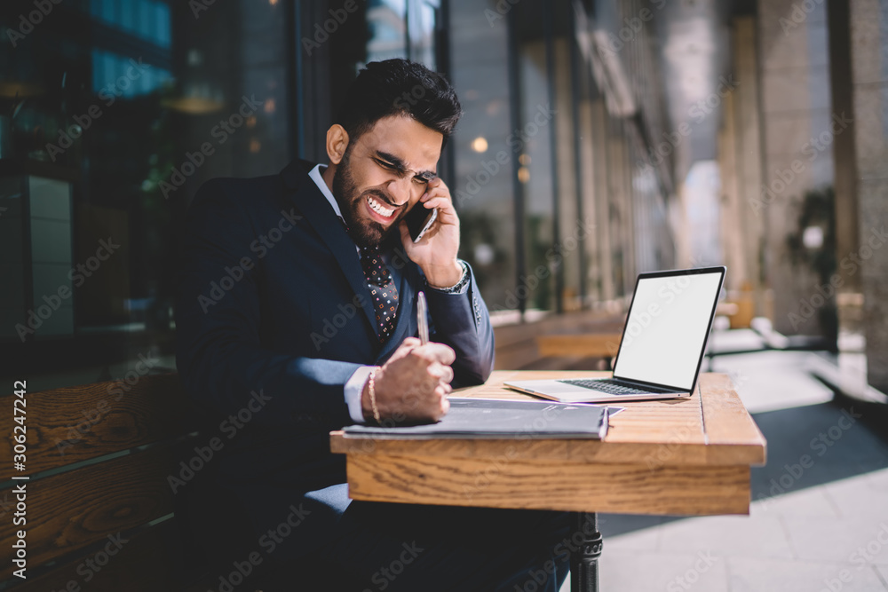 Poster aggressive male banker hitting fist on table with laptop computer with copy space area while communi