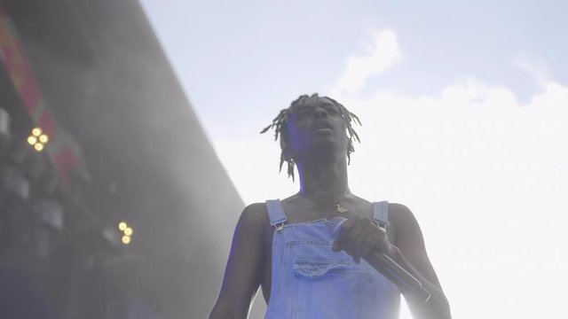 Black rapper in overalls on stage