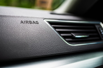 3-D Engraved Airbag Symbol Lettering Bottom Frame Left in Grainy Textured Black Dashboard with Air conditioning system. Interior details.
