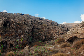 Fototapeta na wymiar Santorini island autumn hills. Volcano soil natural landscape. Mountain caves