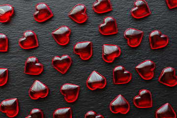 red hearts pattern on black background, flat lay