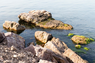 Fototapeta na wymiar Stones on the seashore in a sunny day