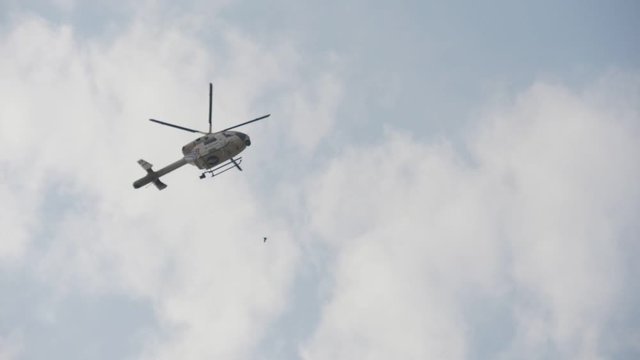 Modern police helicopter flying high in the celeste sky in Belgium in spring in slo-mo