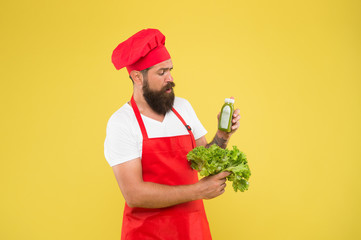 Vitamin smoothie drink. Hipster smoothie beverage. Greenery in bottle. Fresh juice. Squeezing smoothie. Man bearded chef hold lettuce and smoothie bottle yellow background. Vegetarian nutrition