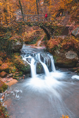 The Schiessentumpel waterfall cascade in Luxembourg Mullerthal trail druring autumn fall in November longexposure photo