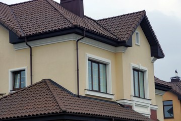  house with windows on a brown wall against a gray sky
