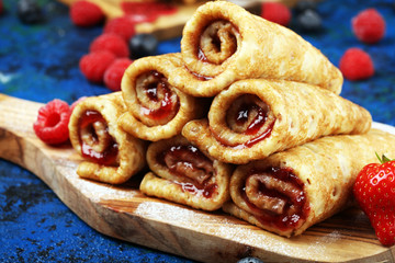 Delicious Tasty Homemade crepes or pancakes with raspberries and mint on rustic background