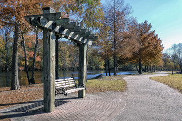 Vacant swing and walkway along the shore of a river of a beautiful autumn day