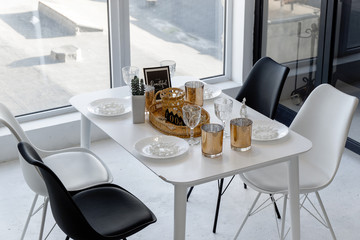 Closeup view from above on bright spacious black and white dining room with a big window and glass wall