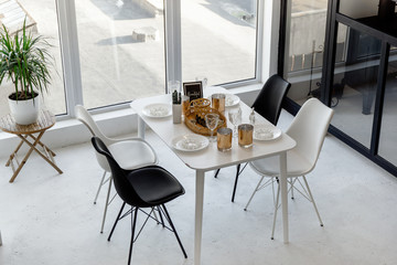 View from above on bright spacious black and white dining room with a big window and glass wall