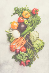 Fresh raw organic vegetables arrangement cabbage carrots broccoli asparagus pepper fennel tomatoes salad on off white background, top view, toned, selective focus