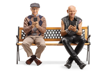 Elderly man and a punker using mobile phones and sitting on a bench
