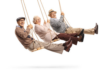 Happy senior people swinging on swings - obrazy, fototapety, plakaty