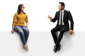 Businessman talking to a young female and sitting on a panel