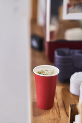 red paper cup with coffee in a coffee shop