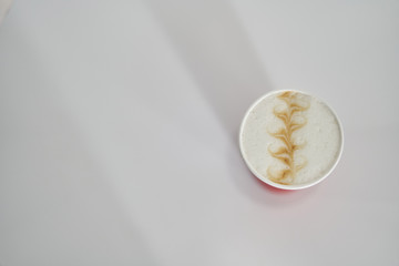 Fototapeta premium red paper cup with coffee in a coffee shop