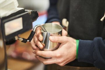 Barista making a hot drink in a coffee shop