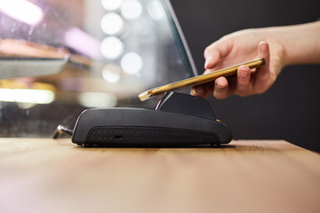 Close up hand paying order by credit card on payment terminal in the coffee shop