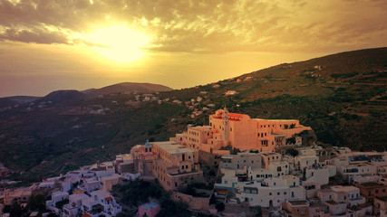 Fototapeta premium Aerial drone photo of iconic uphill Catholic settlement of ano Syra featuring church of Saint George at sunset with beautiful colours, Syros or Siros island, Cyclades, Greece