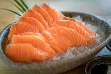 Raw salmon slice or salmon sashimi in Japanese style fresh serve on ice in bowl. Japanese traditional food or with low calories and high nutrition and healthy diet dish. - obrazy, fototapety, plakaty