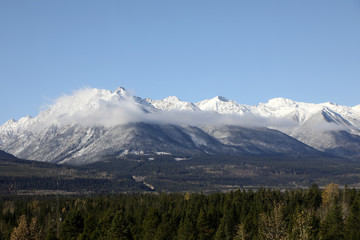 Fototapeta premium The wonderful train journey from Jasper to Vancouver in British Columbia, Canada in Autumn. With train, trees, foliage and snow capped mountains