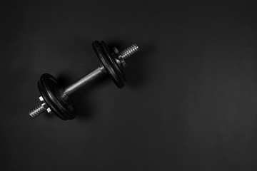 Dumbbell on black background with copy-space