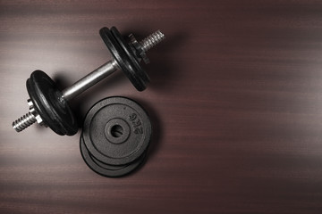 Obraz na płótnie Canvas Dumbbell and weights on wooden background with copy-space