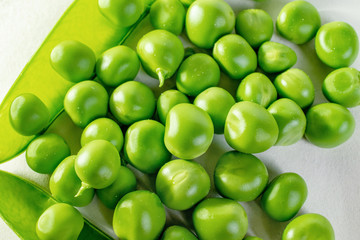 a bunch of fresh green peas on a white background