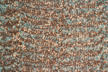 Abstract festive background with round sequins with color transition. Texture fabric embroidered with small shiny and shimmering scales. Celebratory material for creating stage or masquerade costumes.