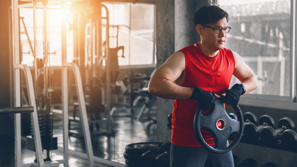 asian strong man doing exercise with weight lifting in gym club