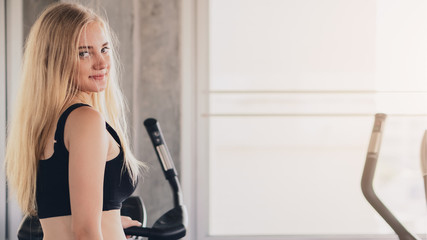 caucasian beautiful young woman in sportswear having workout in gym with treadmill machine