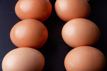 Brown eggs on dark background. Copy space