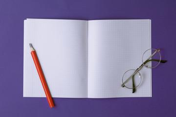 open notebook with pencil and glasses