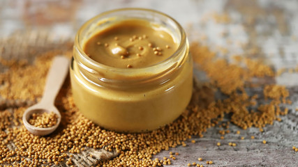 Obraz na płótnie Canvas Jar of fresh homemade mustard. Grains of mustard. Mustard cooking concept. Selective focus. Macro.