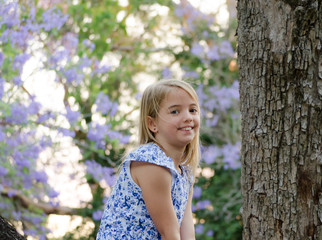 Blonde girl, enjoying nature, outdoor in spring. Jacaranda trees