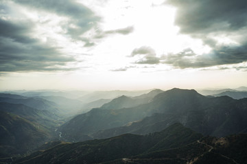 Fabulous view from Moro Rock at Sequoia National Park with a foggy mountains on background and beautiful sun rays highlighting the horizon