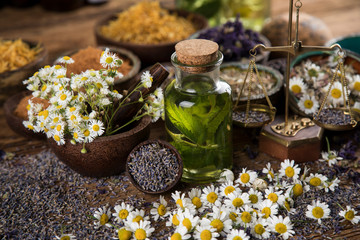Fresh herbs and oils, wooden table background