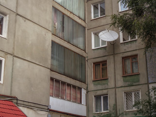 Soviet apartment building. Apartment block. Soviet architecture. Ust-Kamenogorsk (Kazakhstan). Concrete apartment building. Dark. Windows and balconies. Closeup detailed fragment