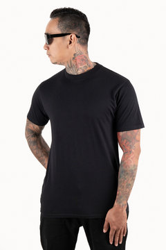 Sixpack man with tattoo wearing black t-shirt short sleeve in front view isolated on white background