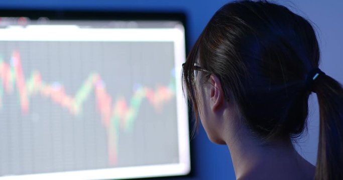 Woman study on computer screen for stock market data at home