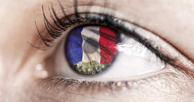 Woman green eye in close up with the flag of France in iris with wind motion. video concept