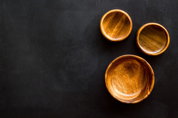 Making wooden dishes. Empty bowls on black background top view copy space