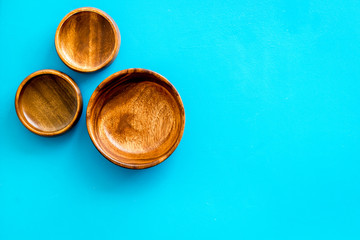 Making wooden dishes. Empty bowls on blue background top view copy space