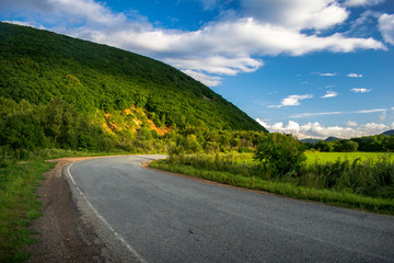 Fototapeta na wymiar Asphalt country road among green hills